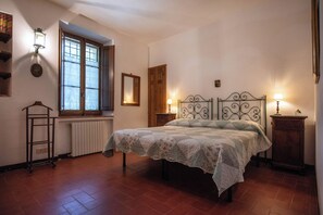Cozy bedroom with a single bed, wooden shutters, and a radiator.