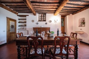 Enjoy meals in this cozy dining area with a wooden table and exposed beams.