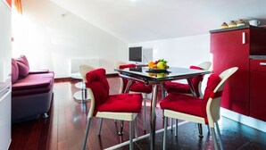 A modern kitchen with a dining table, chairs, and a red cabinet. - Elegant and Lavish Leisure Apartments Zadar With Outdoor Pool (Zadar)