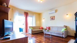 A living room with a flat-screen TV, two sofas, a coffee table, and a wooden floor. - Elegant and Lavish Leisure Apartments Zadar With Outdoor Pool (Zadar)