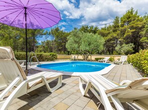 A swimming pool with lounge chairs and an umbrella. - Elegant and Lavish Leisure Apartments Zadar With Outdoor Pool (Zadar)
