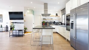 A modern kitchen with a large island, stainless steel appliances, and a flat-screen TV mounted on the wall. - Home2Book Chic Penthouse with Terrace, Santa Cruz (Santa Cruz de Tenerife)