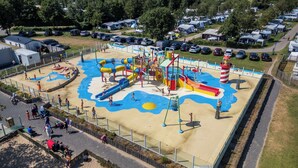 A water park with slides, a wave pool, and a sandy play area.