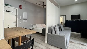 Een moderne woonkamer met een houten eettafel, een bank en een televisie.