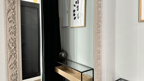 A modern interior with a black door, a glass shelf with a wooden top, and a framed artwork on the wall. - PlazaMayorSuites Ext PARQUE DEL OESTE (Madrid)