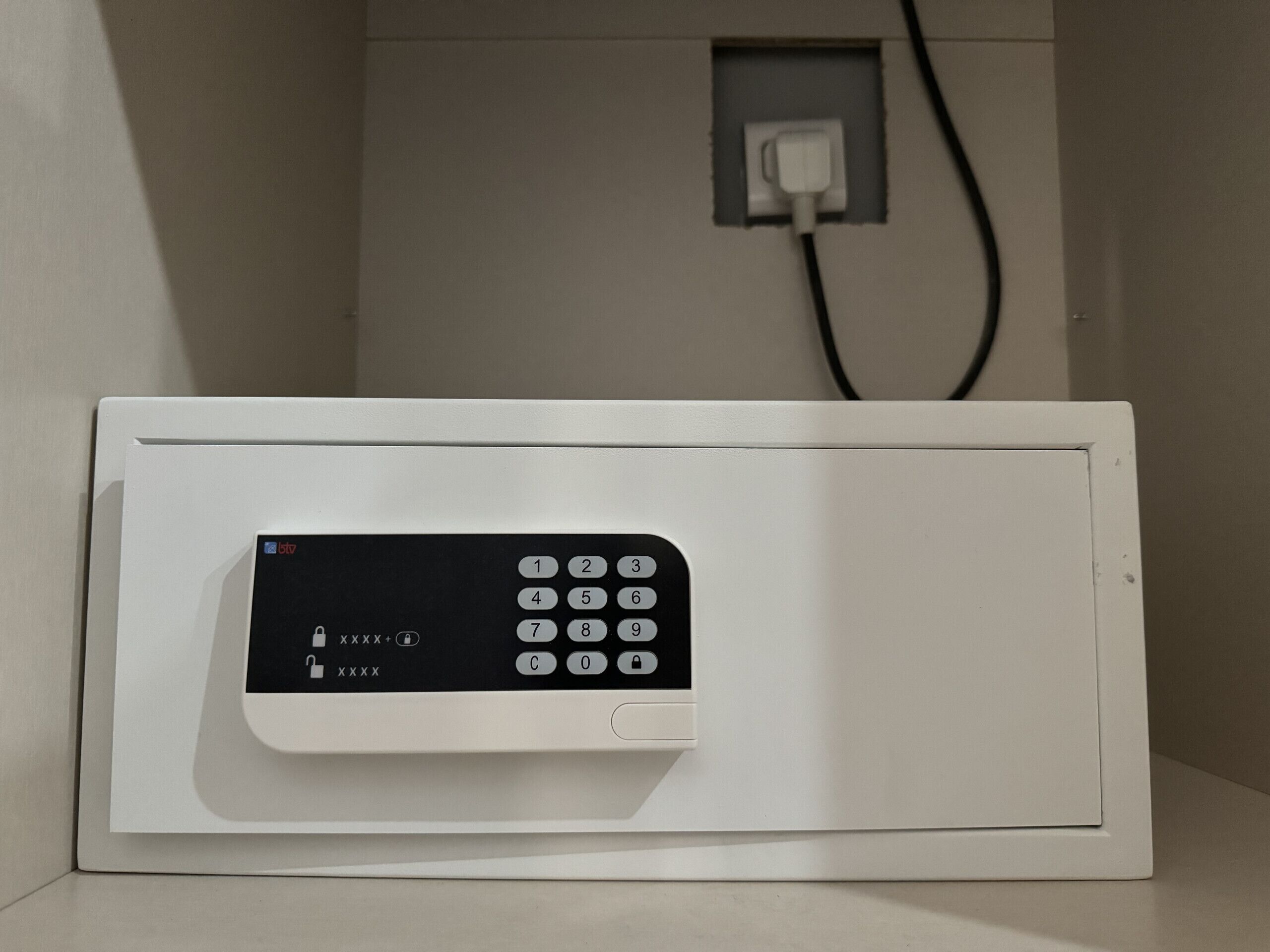 Un four à micro-ondes blanc doté d’un clavier numérique, d’une prise de courant et d’un câble branché.