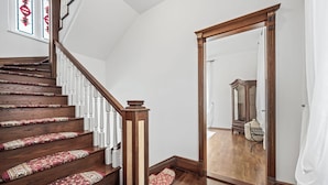 A wooden staircase with patterned carpet runners, white balusters, and a mirror in the adjacent room. - Your Royal Retreat: Luxury Villa Anna in Split's Old Town (Split)