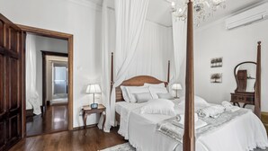 A four-poster canopy bed with white linens, a wooden floor, a small bedside table with a lamp, and a mirror on the wall. - Your Royal Retreat: Luxury Villa Anna in Split's Old Town (Split)