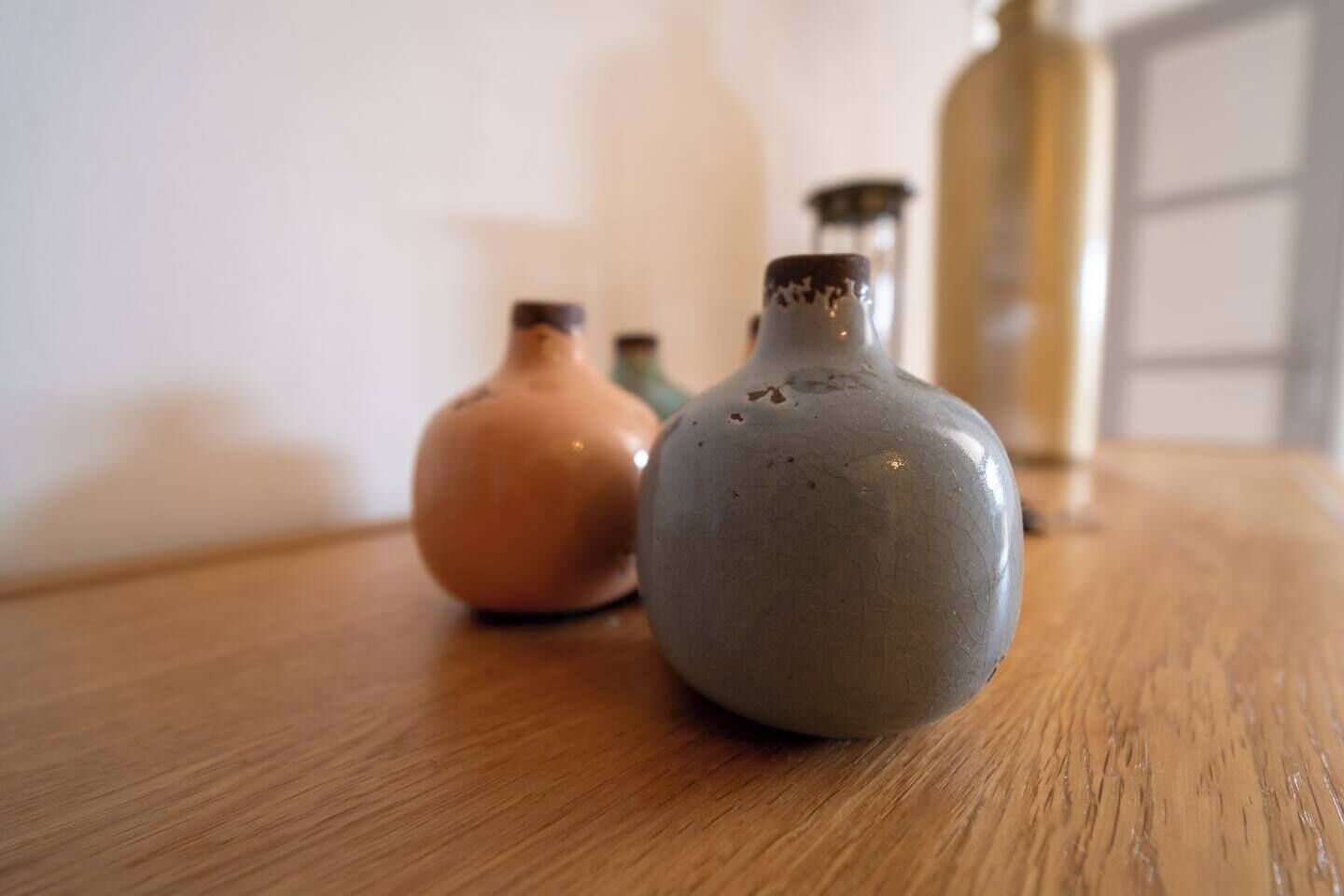 Three ceramic vases on a wooden table.