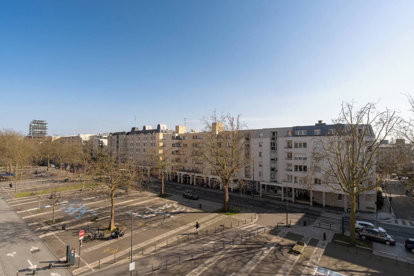 A multi-story residential building with a parking lot in front.
