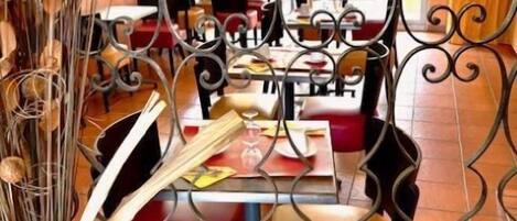 A dining area with a metal partition, chairs, and tables.