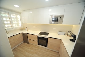 Een moderne keuken met een ingebouwde magnetron, oven en broodrooster.