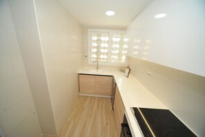 A small kitchen with a window, a sink, and a stove.