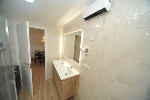 A bathroom with a double sink, a mirror, and an air conditioning unit. - ESTORIL BLOCK 3 PREMIUM (Benicàssim)