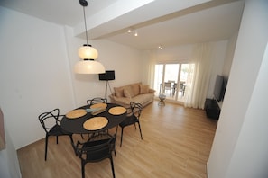 Un espace repas comprenant une table ronde, des chaises et un luminaire suspendu.