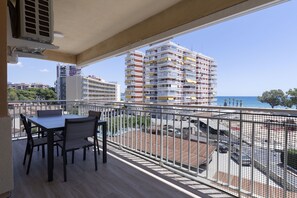 A balcony with a table and chairs, overlooking a parking area and buildings with balconies. - ESTORIL BLOCK 3 PREMIUM (Benicàssim)