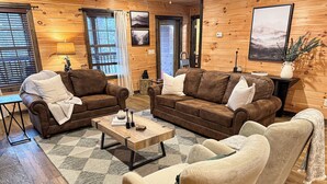 Un salon chaleureux avec deux canapés en cuir marron, un fauteuil beige et une table basse.