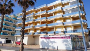A multi-story building with balconies, a supermarket, and a parking area. - MOLI DE VENT SUPERIOR (Peñiscola)