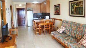 A living room with a sofa, a TV, and a dining area with a table and chairs. - MOLI DE VENT SUPERIOR (Peñiscola)