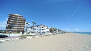 A beachfront hotel with multiple floors, a sandy beach in the foreground, and a clear blue sky. - DA VINCI SUPERIOR SEA VIEW (Peñiscola)