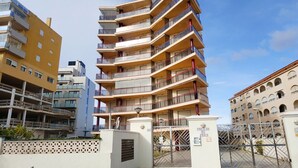 A multi-story building with balconies, a gated entrance, and a clear sky. - DA VINCI SUPERIOR SEA VIEW (Peñiscola)