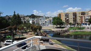 Vista de una zona residencial con un río, un puente y un parque infantil.