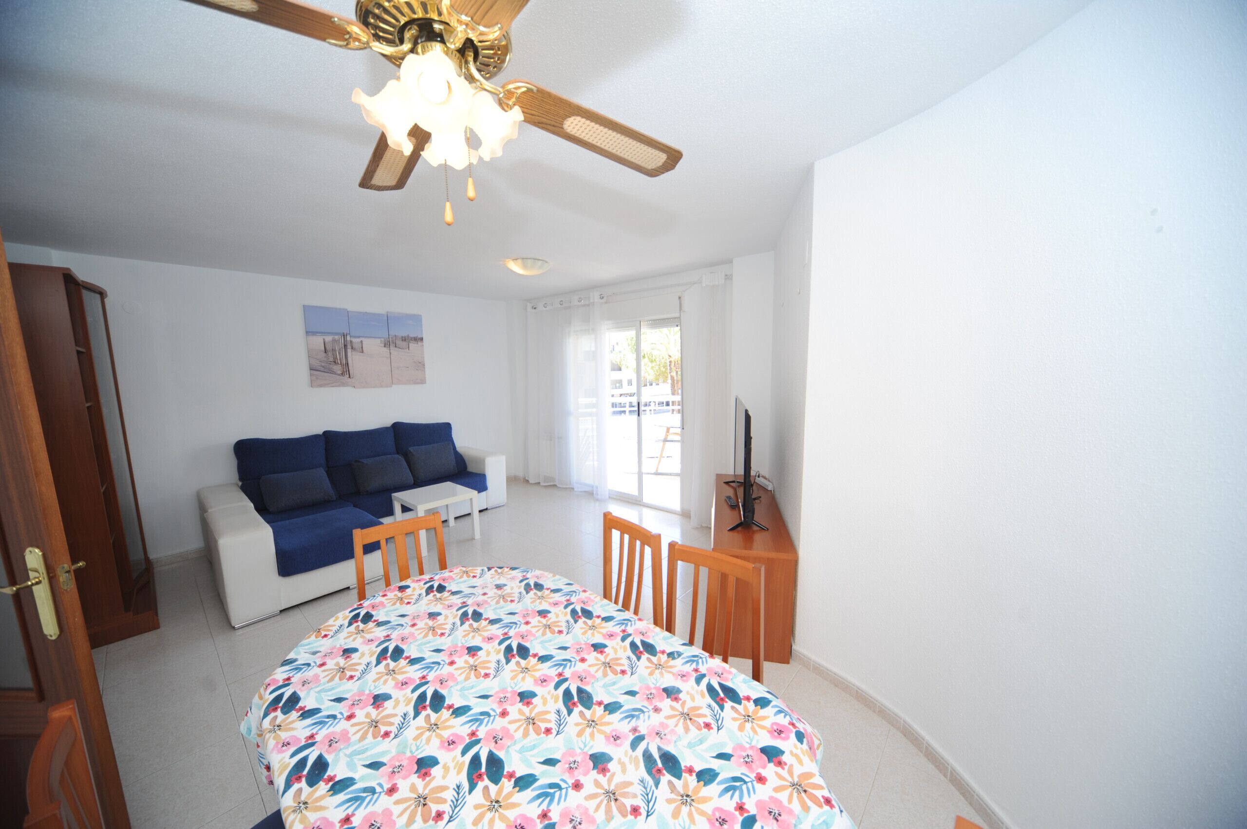 Ein Schlafzimmer mit Bett, Sofa, Schreibtisch und Deckenventilator.
