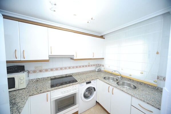 Fridge, microwave, coffee/tea maker, cookware/dishes/utensils
