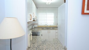 A compact kitchen with a sink, countertop, and cabinets. - BAIX MAESTRAT (Peñiscola)