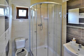 Contemporary bathroom with a glass-enclosed shower, toilet, and sink.