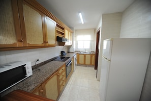 Fridge, microwave, coffee/tea maker, cookware/dishes/utensils