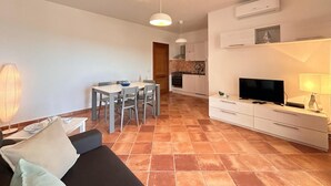 Un saló modern amb un sofà, televisió i zona de menjador.