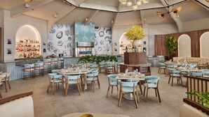 Un restaurant spacieux avec de hauts plafonds, un bar central et de nombreux espaces de détente.