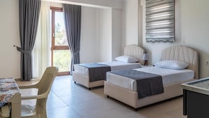 A hotel room with two beds, a desk, and a chair. - Söğüt Butik Apart (Sögüt)
