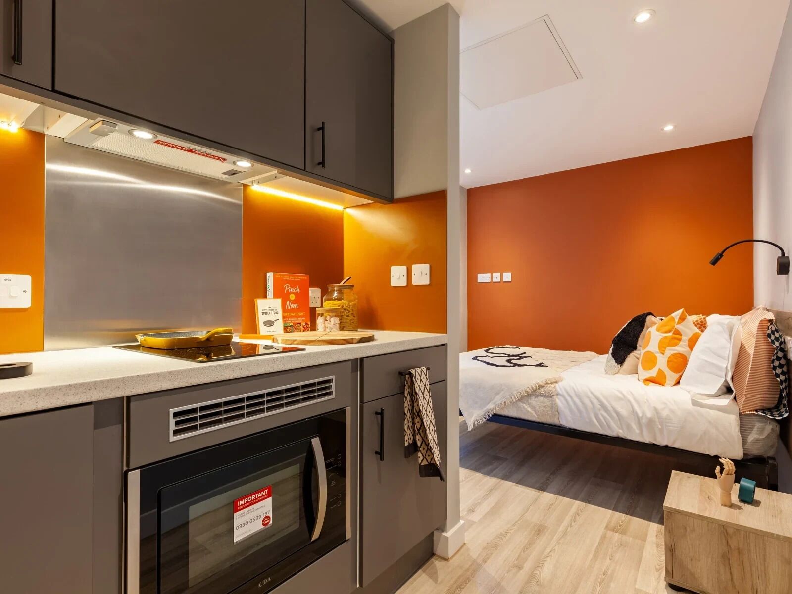 A compact kitchenette with a microwave, oven, and countertop.