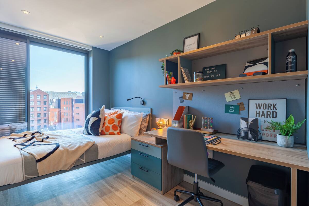 Une chambre à coucher moderne avec un lit, un bureau et une étagère.