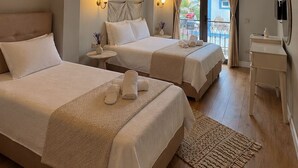 A hotel room with two beds, a balcony, a small table, and a ceiling with exposed beams. - No9 Alacati (Cesme)