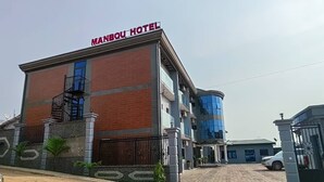Un hotel con un cartello ben visibile, un ingresso sorvegliato e un vialetto lastricato.