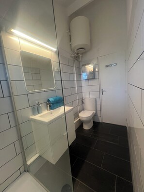 Regadera, toallas, papel de baño 