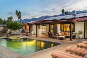 A residential property with a swimming pool, outdoor furniture, and a patio area.