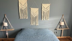 A room with a bed, macramé wall hangings, and two hanging lamps. - Quiet country house (Houdain-lez-Bavay)