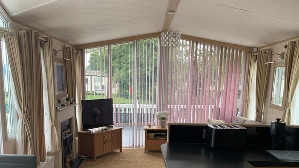 A modern kitchen with a large island, a dining area with a table and chairs, and a living area with a sofa and TV. - VALENCIA 2 BEDROOMS LAKESIDE LODGE (Weeley)