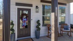 A front door with a wreath, two potted plants, and two rocking chairs on the porch. - Colonel's Cottage Oxford - 2mi to The Square (Oxford)