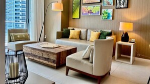 A modern living room with a sofa, armchairs, a coffee table, and artwork on the wall. - Enjoy a luxurious apartment on the beach! (Hollywood)