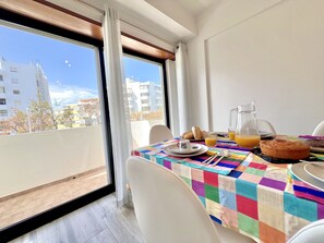A balcony with a table set for breakfast, including croissants, juice, and a muffin. - Quarteira Brightness by Homing (Loulé)