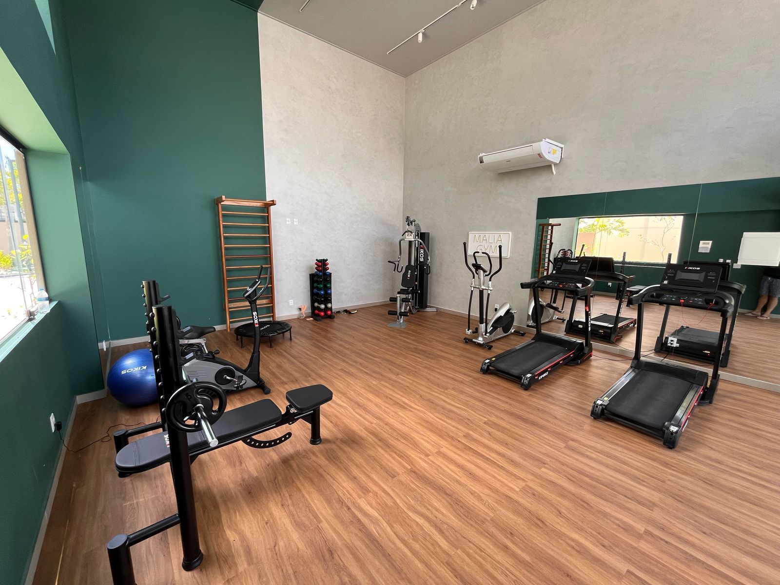 A gym with various exercise equipment, including treadmills, a bench press, and a stationary bike.