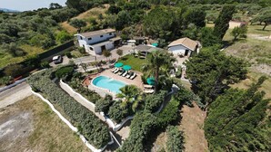 A residential property with a swimming pool, multiple houses, and surrounding greenery. - Villa Piccola Stella with attached annex and private pool (Sardegna)