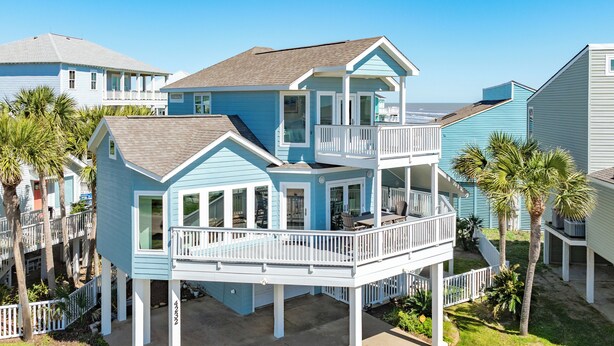 Une maison à deux étages située en bord de mer, dotée d’un balcon, d’une terrasse couverte et d’une petite piscine.