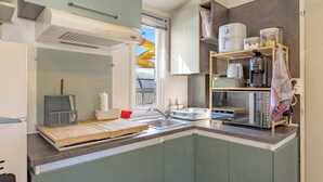 A compact kitchen with a built-in microwave, a coffee maker, and a toaster.