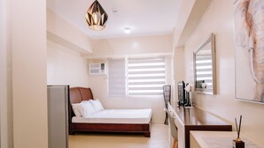 A bedroom with a bed, bedside table, and a mirror. - Heart of the City Cozy Nook (Iloilo)